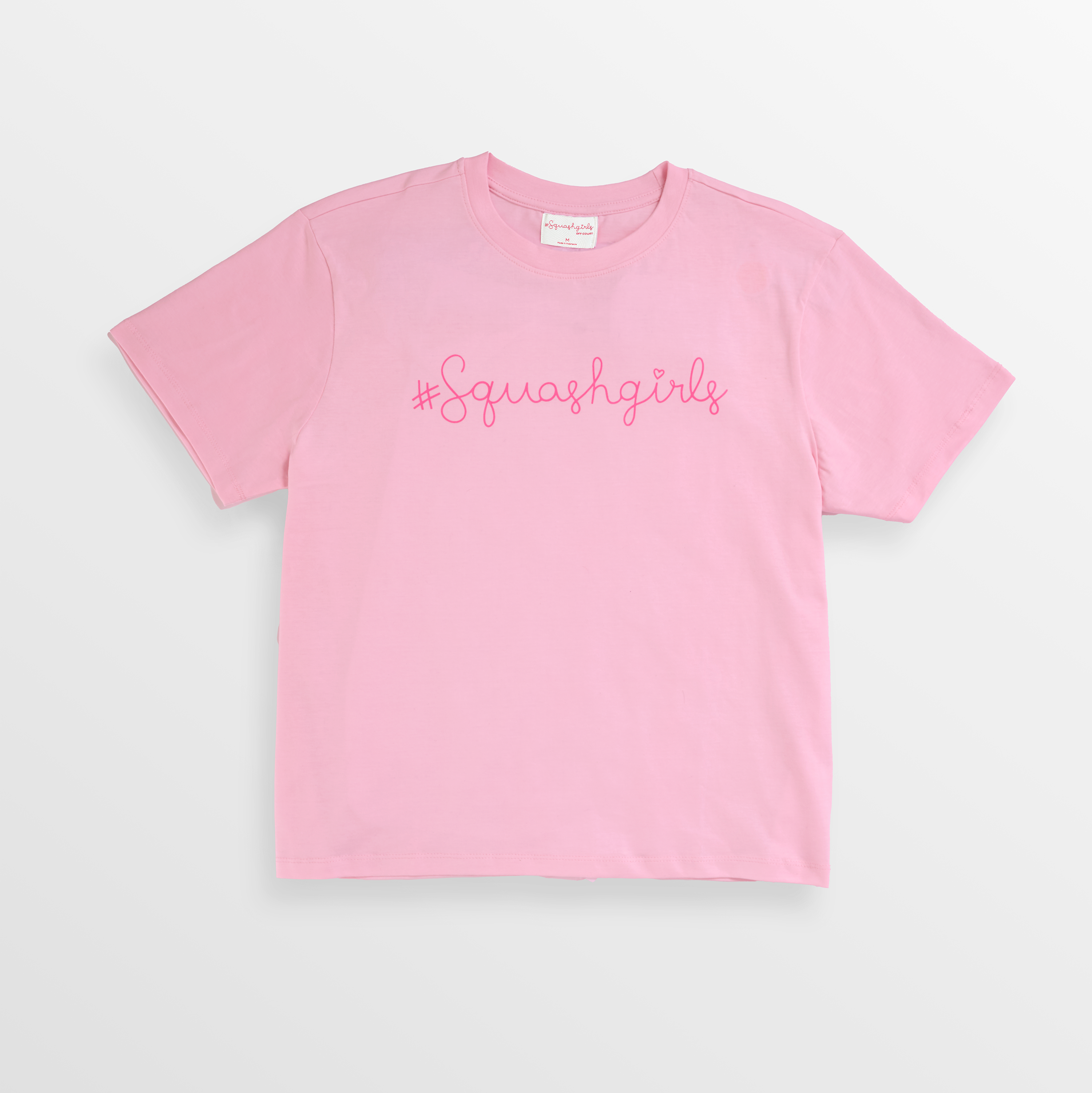 Pink t-shirt with '#Squashgirls' text on a light gray background