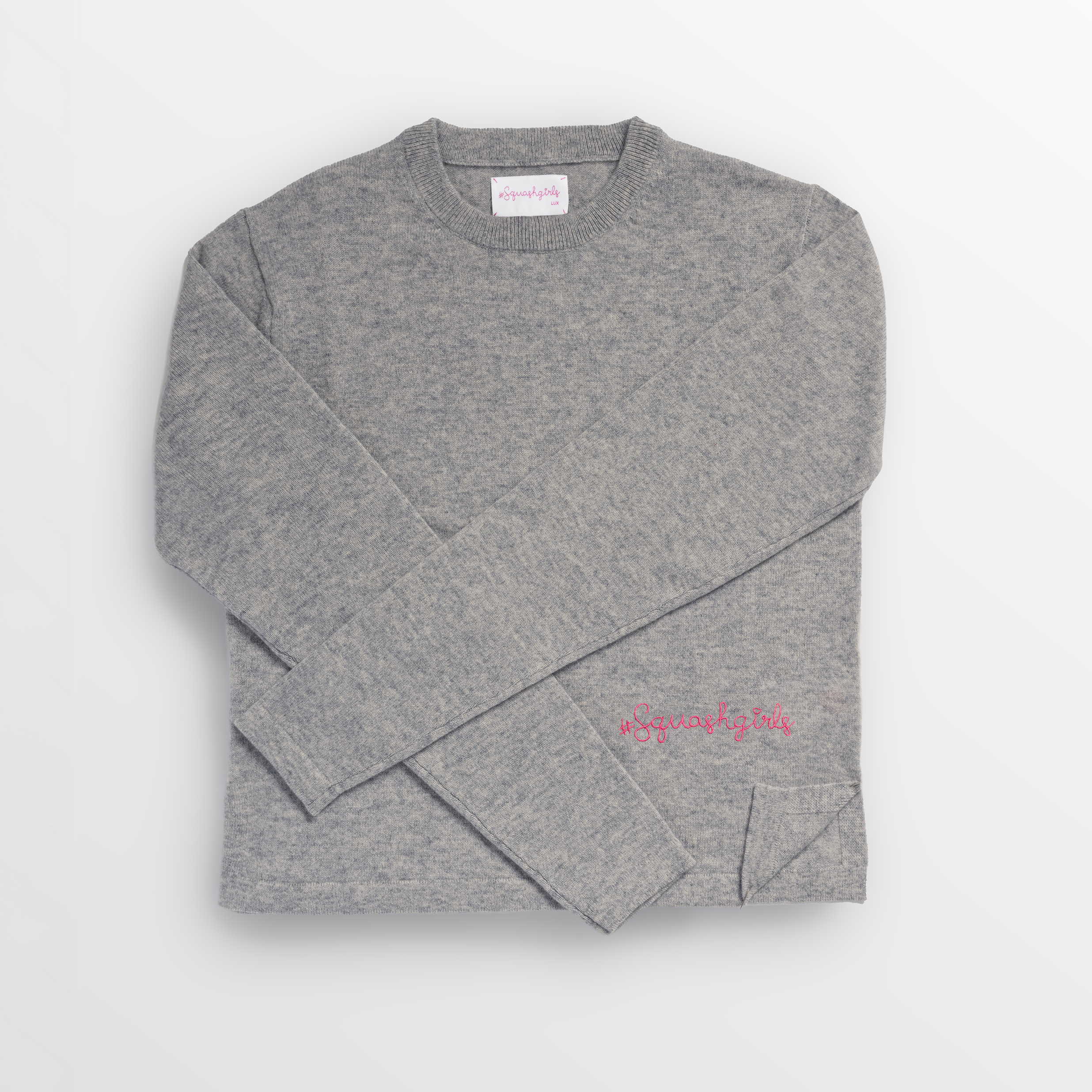 Folded gray cashmere sweater with "squashgirls" text.