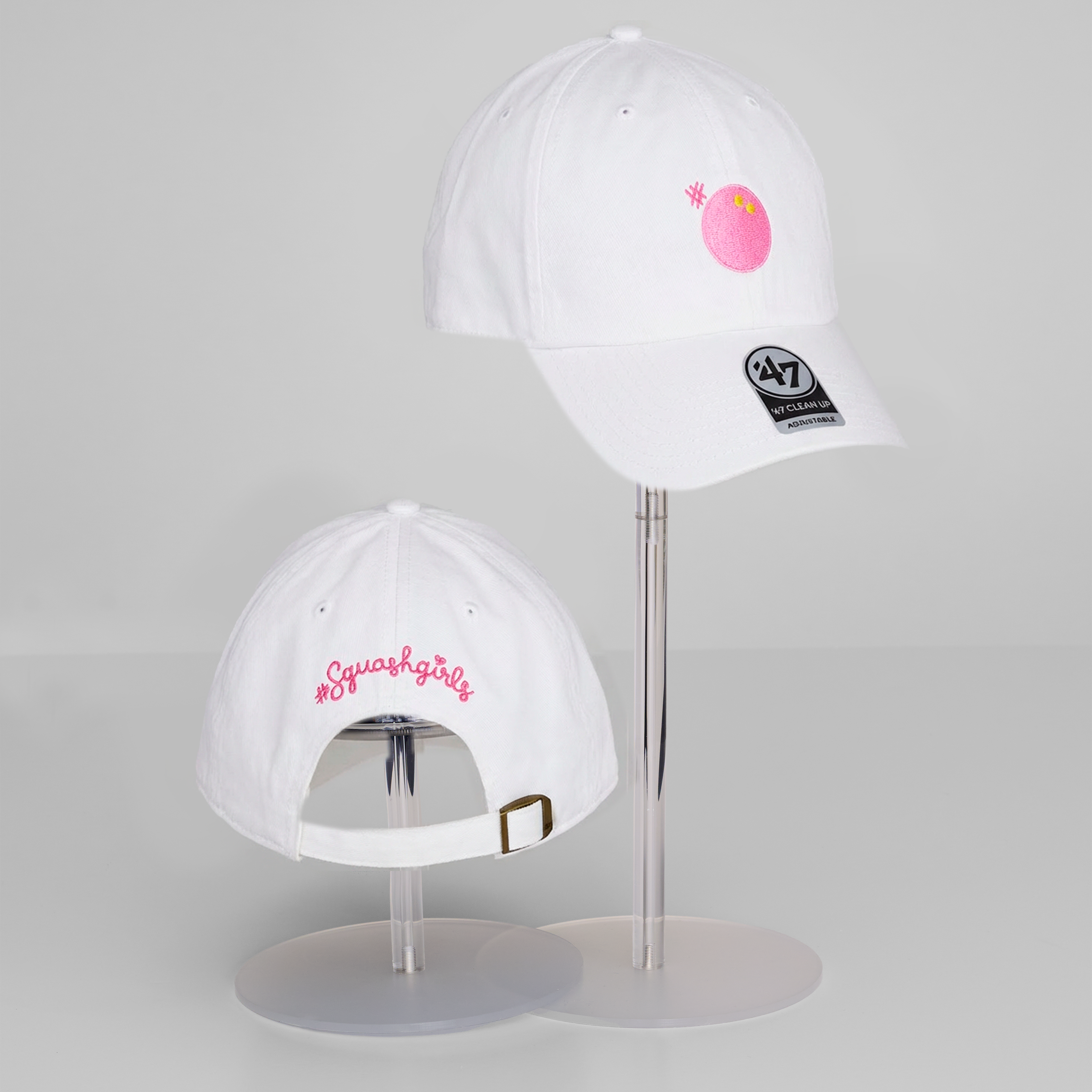 Two white baseball caps with logos on a gray background